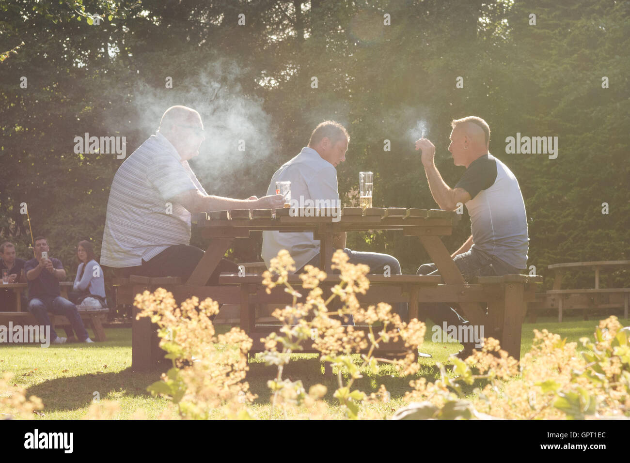 Raucher in einer Kneipe Biergarten in Schottland, UK, umgeben von Rauch Stockfoto