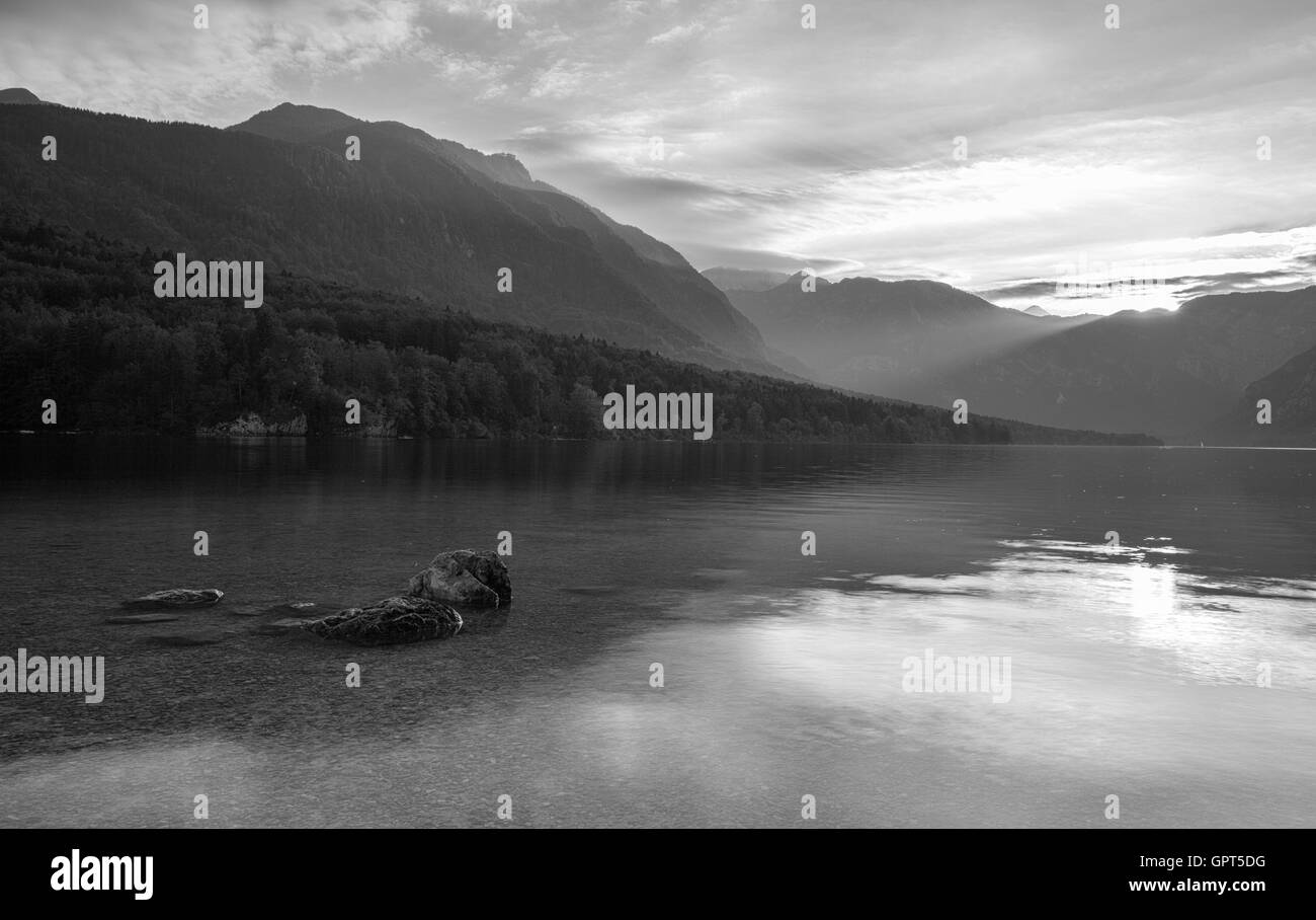 Reflexion der Landschaft in den See. Sonnenuntergang am Bohinj See in Slowenien. Mystische Landschaft an einem Sommertag mit dramatischen lig Stockfoto