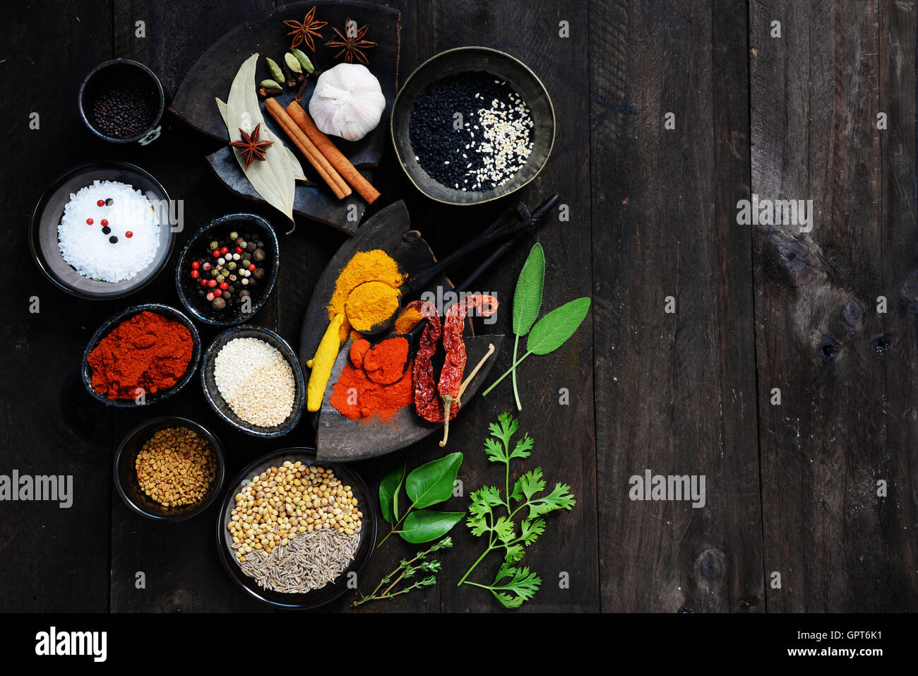 Gewürze und Kräuter auf dunklem Holz mit textfreiraum für Text. Essen und Küche Zutaten Stockfoto