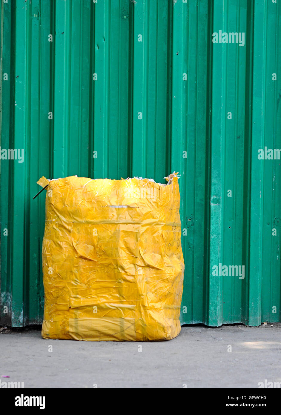 gelben Müll Tasche vorne grün Zaun Stockfoto