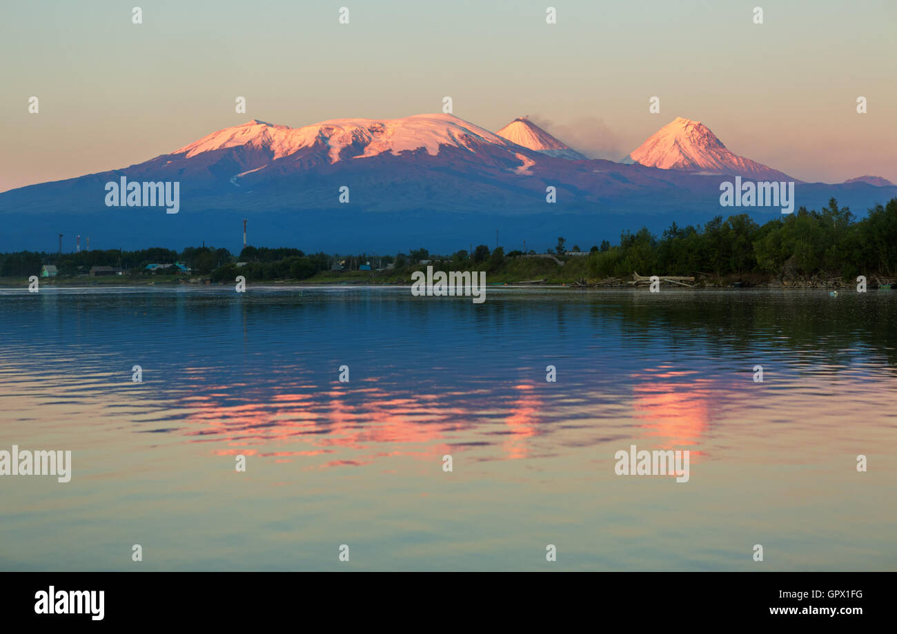 Sonnenuntergang Kluchevskaya Lichtkonzern der Vulkane mit Spiegelbild im Fluss Kamtschatka. Stockfoto