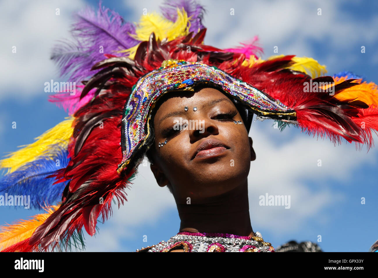 Eine Frau in einer bunten gefiederten Kopfschmuck Tänze an der Leeds West Indian Karneval in Leeds, West Yorkshire. Stockfoto