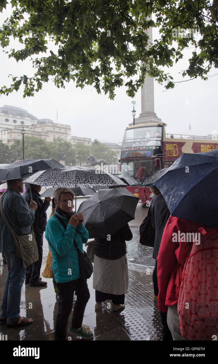 Menschen warten, um Cross Road am Trafalgar Square im Regen - London-UK Stockfoto