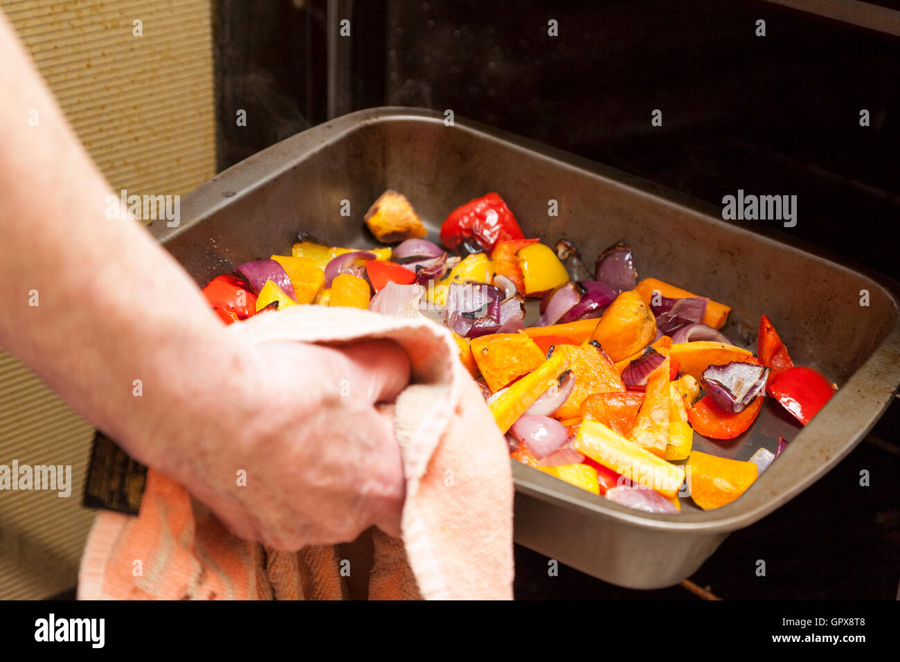 Home Kochen. Person, die ein Fach aus gerösteten Gemüse aus dem Ofen Stockfoto