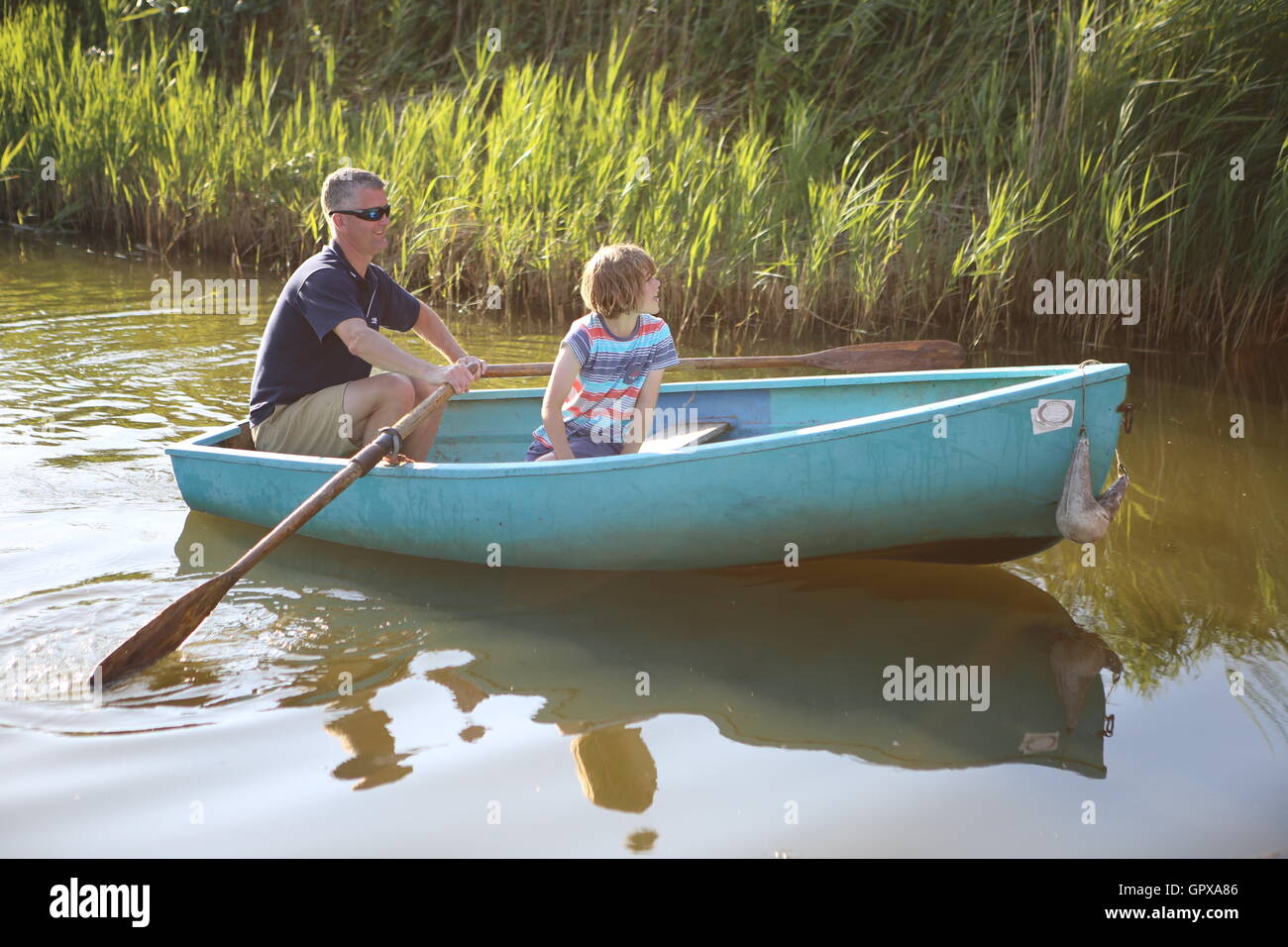 Mann und Kind im Ruderboot Norfolk Broads UK Stockfoto