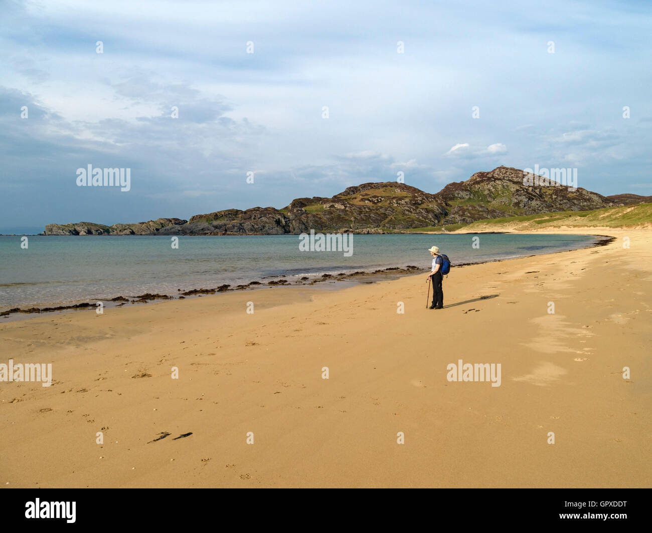 Einsame weibliche Walker an wunderschönen einsamen Sandstrand in Kiloran Bay auf der Hebridean Insel Colonsay, Schottland. Stockfoto