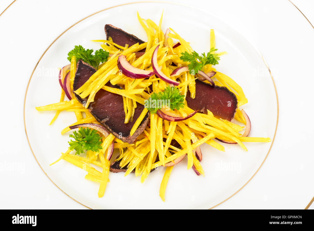 Salat von gelben Rüben mit roten Zwiebeln und Dörrfleisch Stockfoto