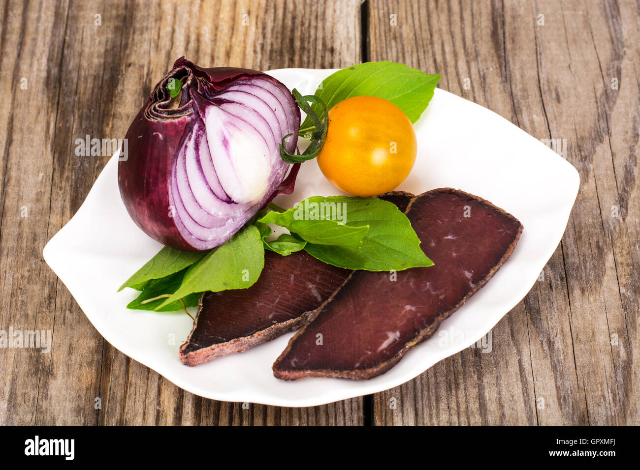 Salat von gelben Rüben mit roten Zwiebeln und Dörrfleisch Stockfoto