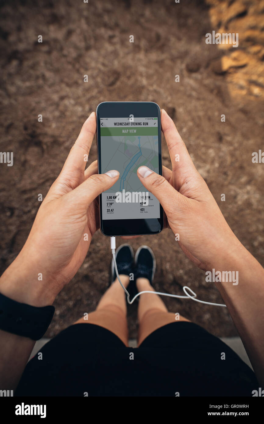 POV-Shot der weibliche Läufer mit einer Fitness-app auf ihr Handy. Überprüfen die Zusammenfassung ihrer weiblichen laufen auf Smartphone. Stockfoto