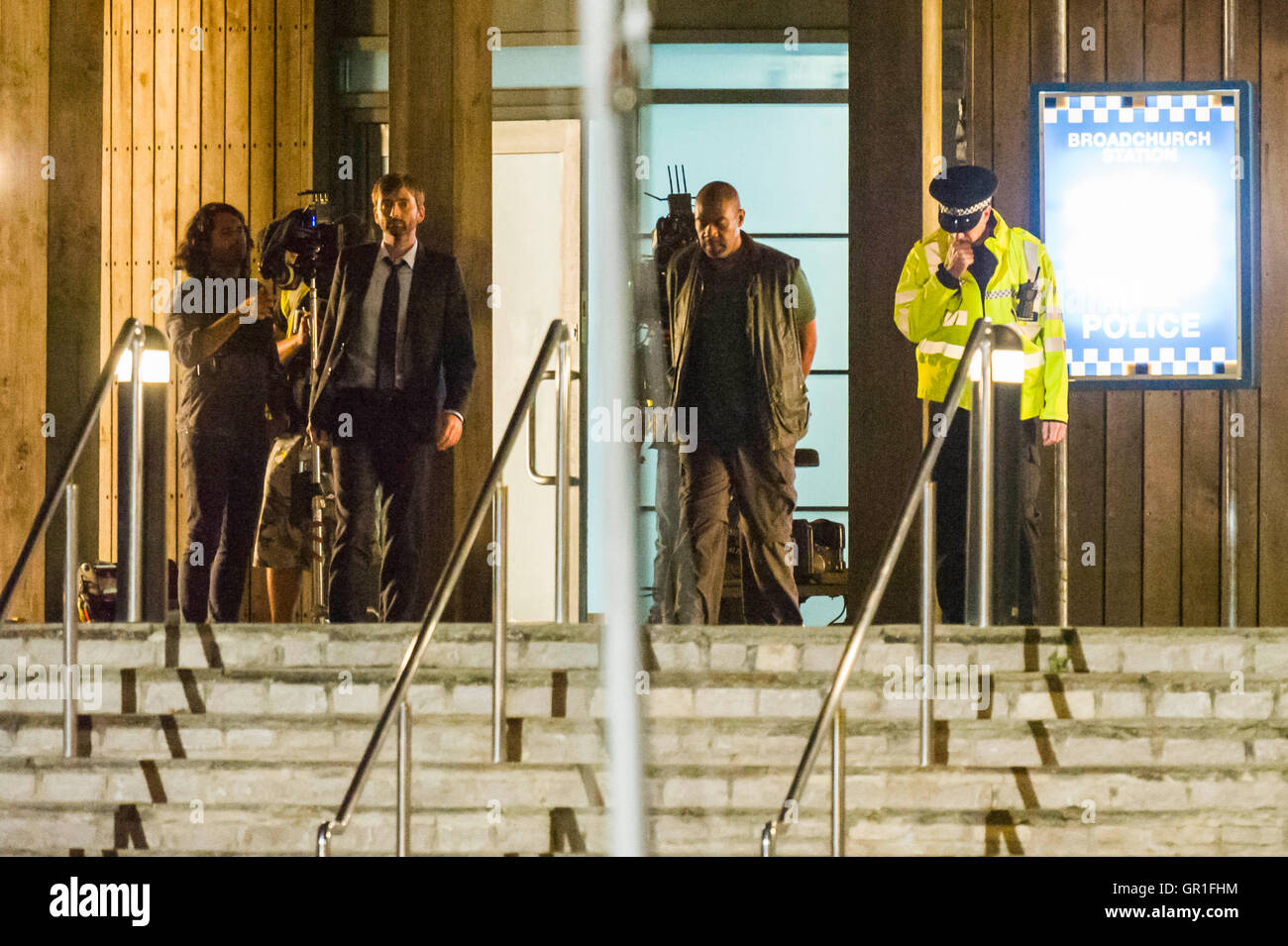 West Bay, Dorset, UK-hit 6. September 2016 - David Tennant und Sir Lenny Henry Dreharbeiten Verhaftung Szene auf der Treppe von der Polizei in der Nacht für Serie 3 der ITV-Serie Broadchurch.  Ed Burnett, der Charakter gespielt von Sir Lenny Henry sieht in Gewahrsam in Handschellen von DI Alec Hardy gespielt von David Tennant, nachdem er eines der Zeichen zeigt Jim Atwood angegriffen genommen werden.  Bild: Graham Hunt/Alamy Live-Nachrichten Stockfoto