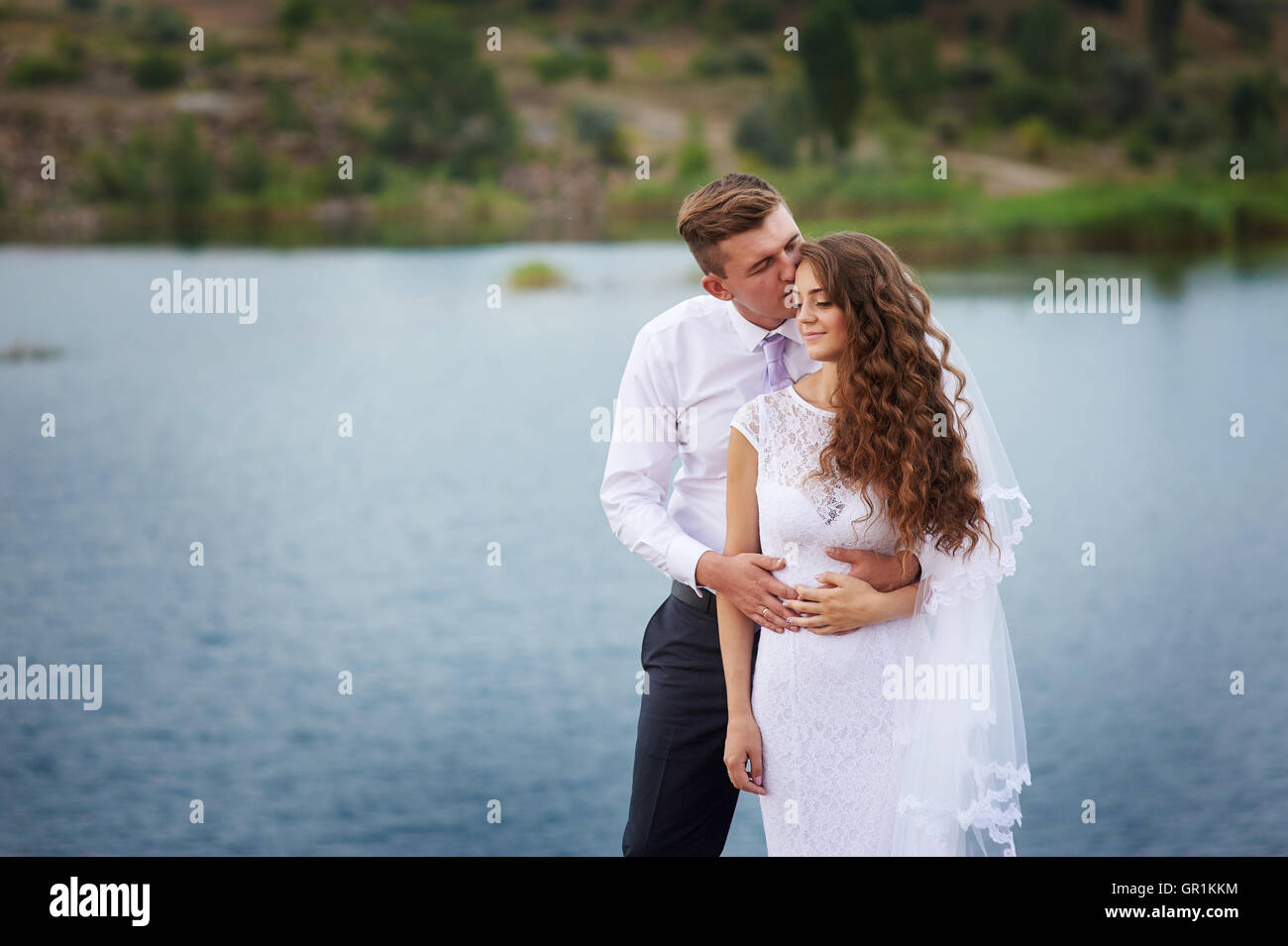 schöne junge Paare, die nahe dem See am Tag Hochzeit Stockfoto