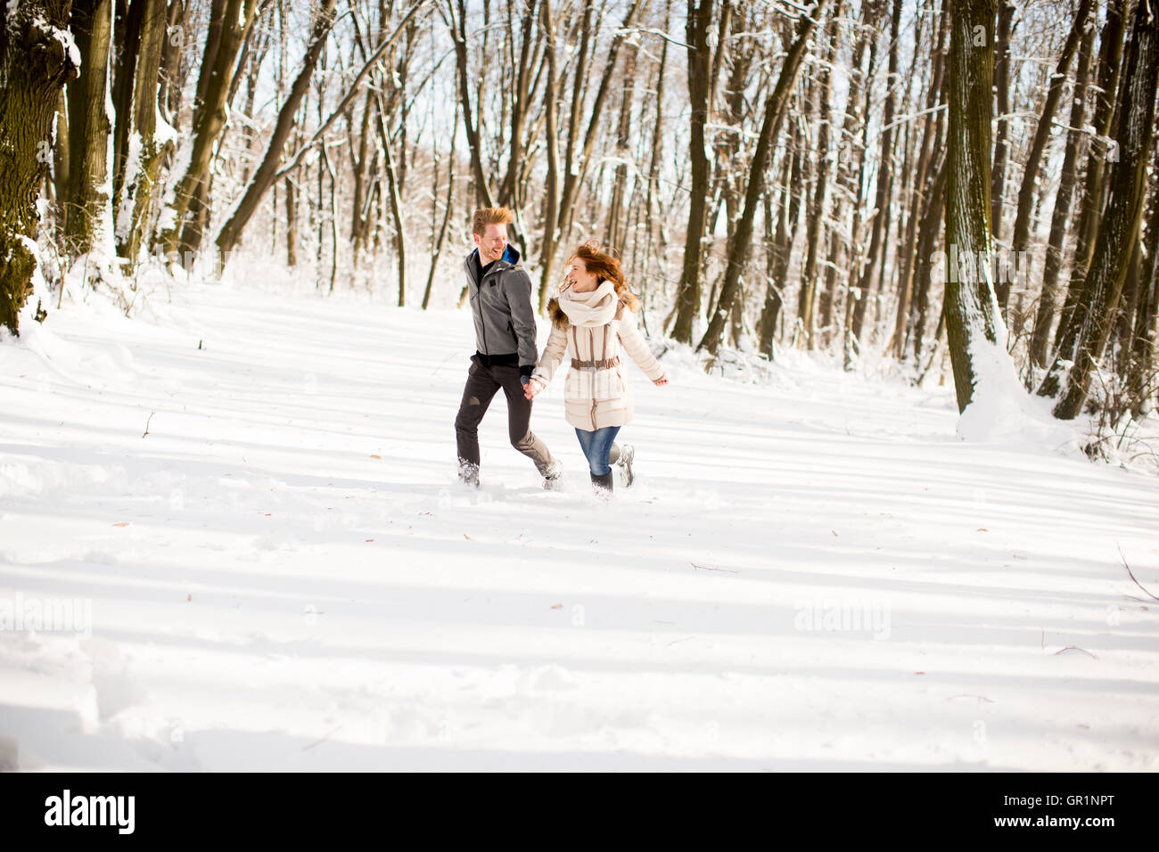 Junge Paare, die Spaß im Schnee im park Stockfoto