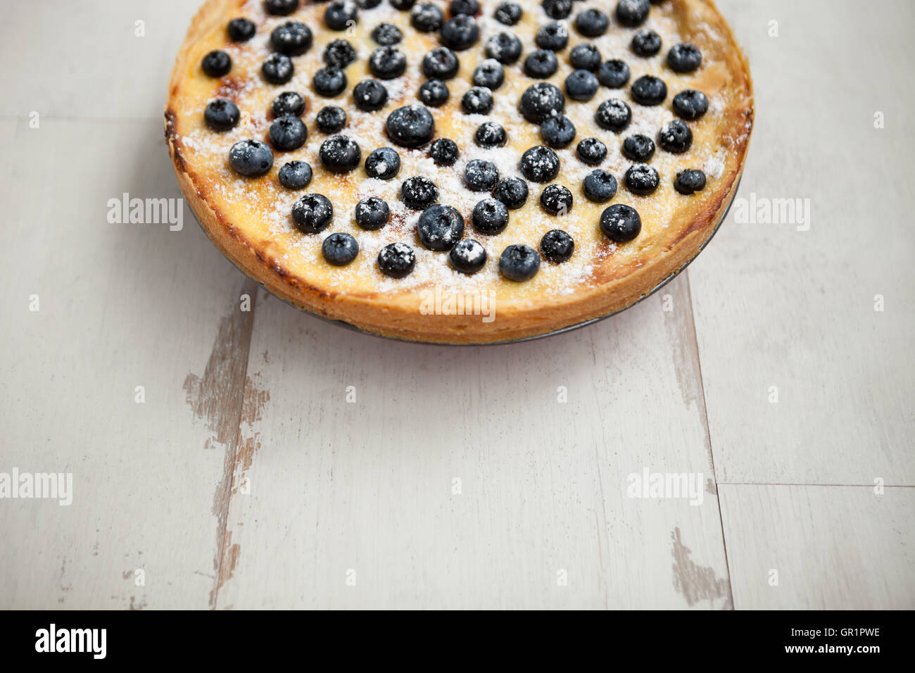 Hausgemachten Heidelbeerkuchen auf Holztisch. Leckeres Gebäck mit Puderzucker, frische Beeren und cremigen Teig. Textfreiraum, statt text Stockfoto