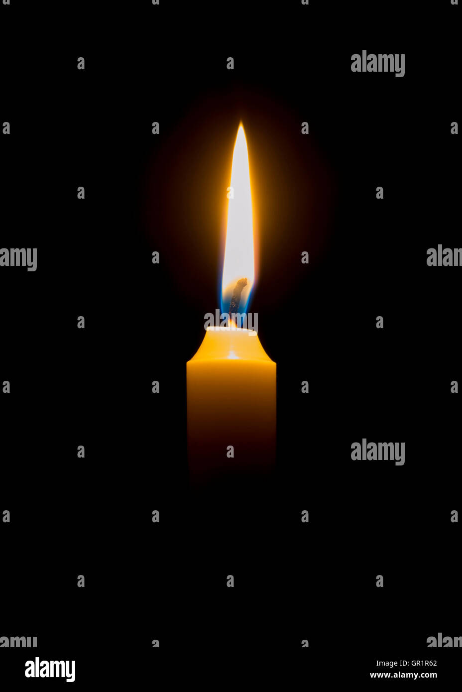 Brennende Kerze in einem abgedunkelten Raum. Stockfoto