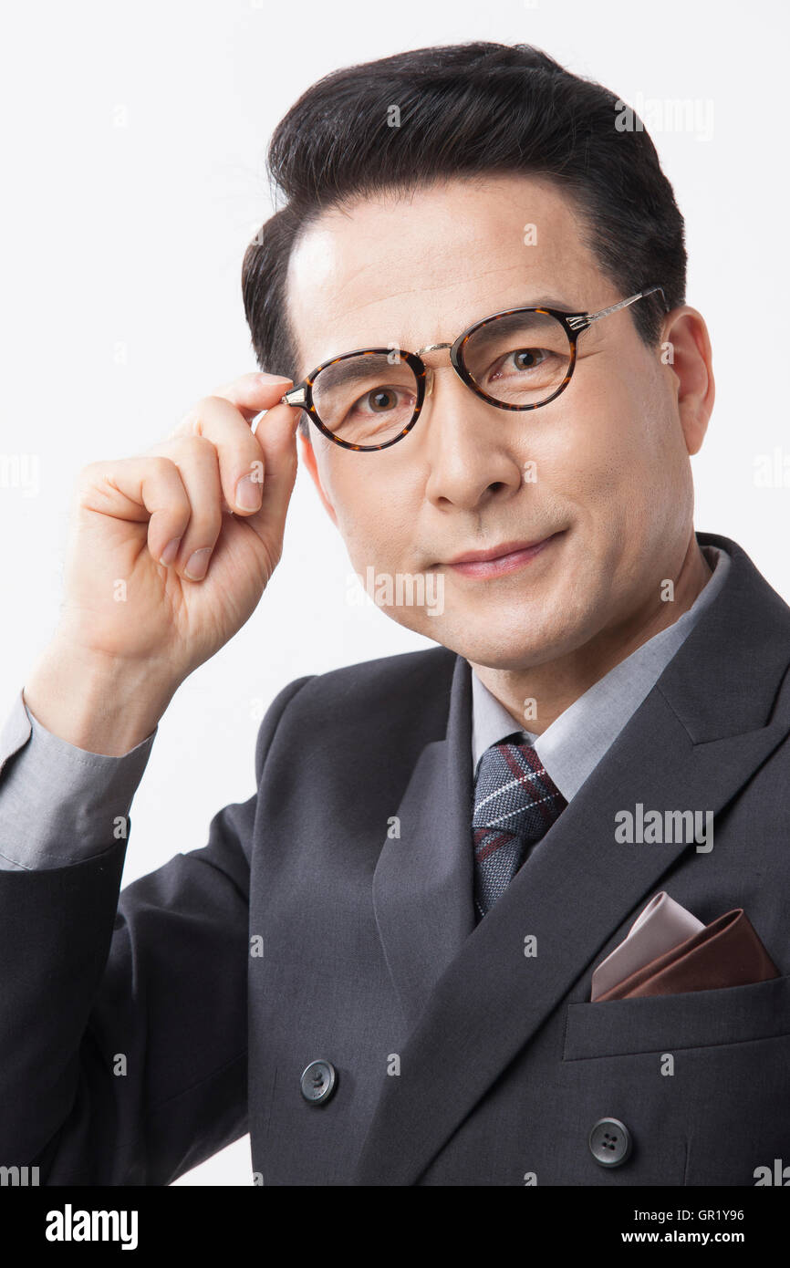 Porträt des mittleren Alter Geschäftsmann berühren seine Brille Stockfoto
