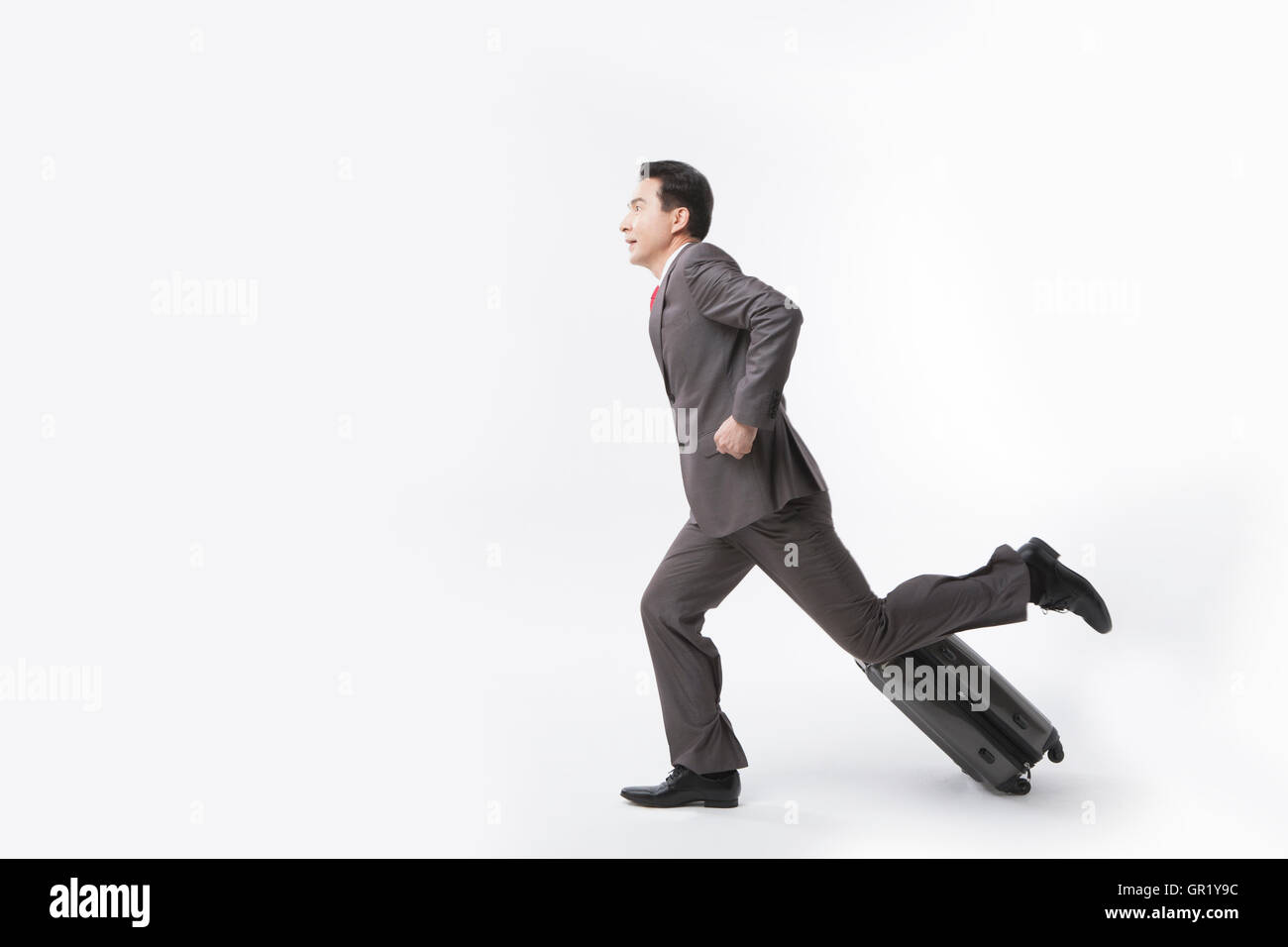 Seitenansicht des mittleren Alter Geschäftsmann laufen ziehen Träger Stockfoto