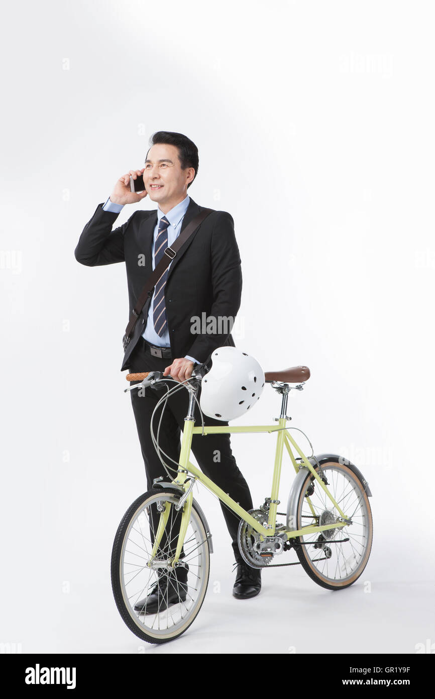 Lächelnd Mitte im Alter Geschäftsmann mit Fahrrad am Handy sprechen Stockfoto