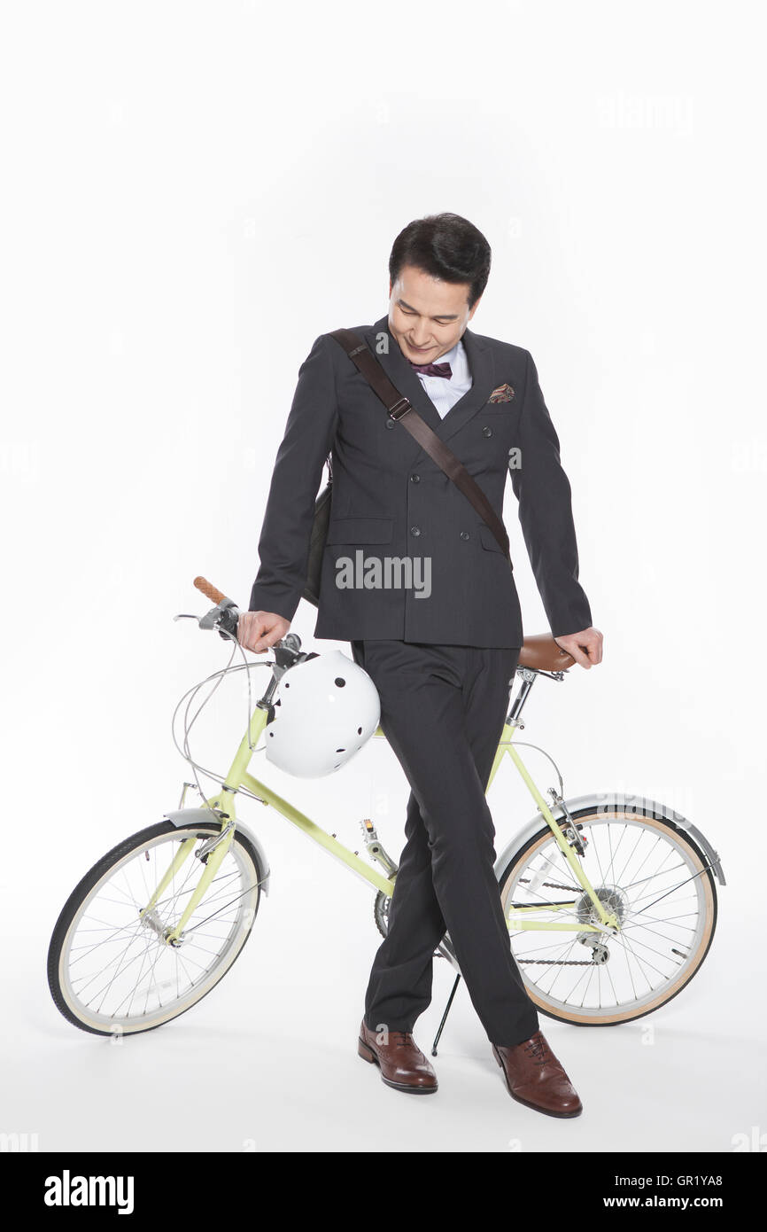 Lächelnd Mitte im Alter Geschäftsmann posiert auf Fahrrad nach unten Stockfoto