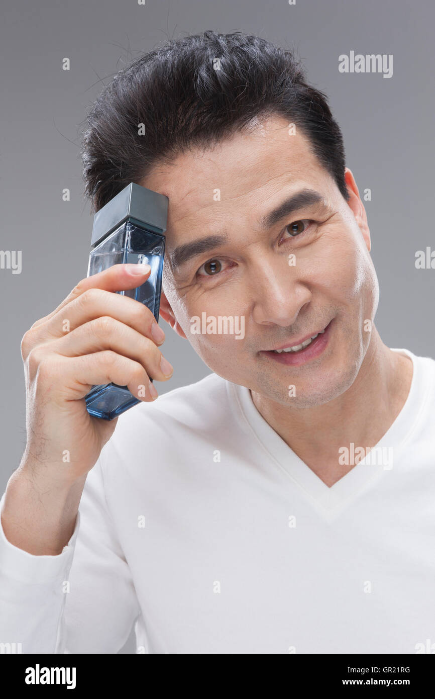 Applying Mann mit Kosmetik Stockfoto