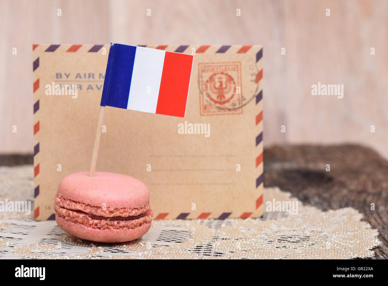 Französische Flagge auf einem rosa Macaron vor Vintage Umschlag. Stockfoto
