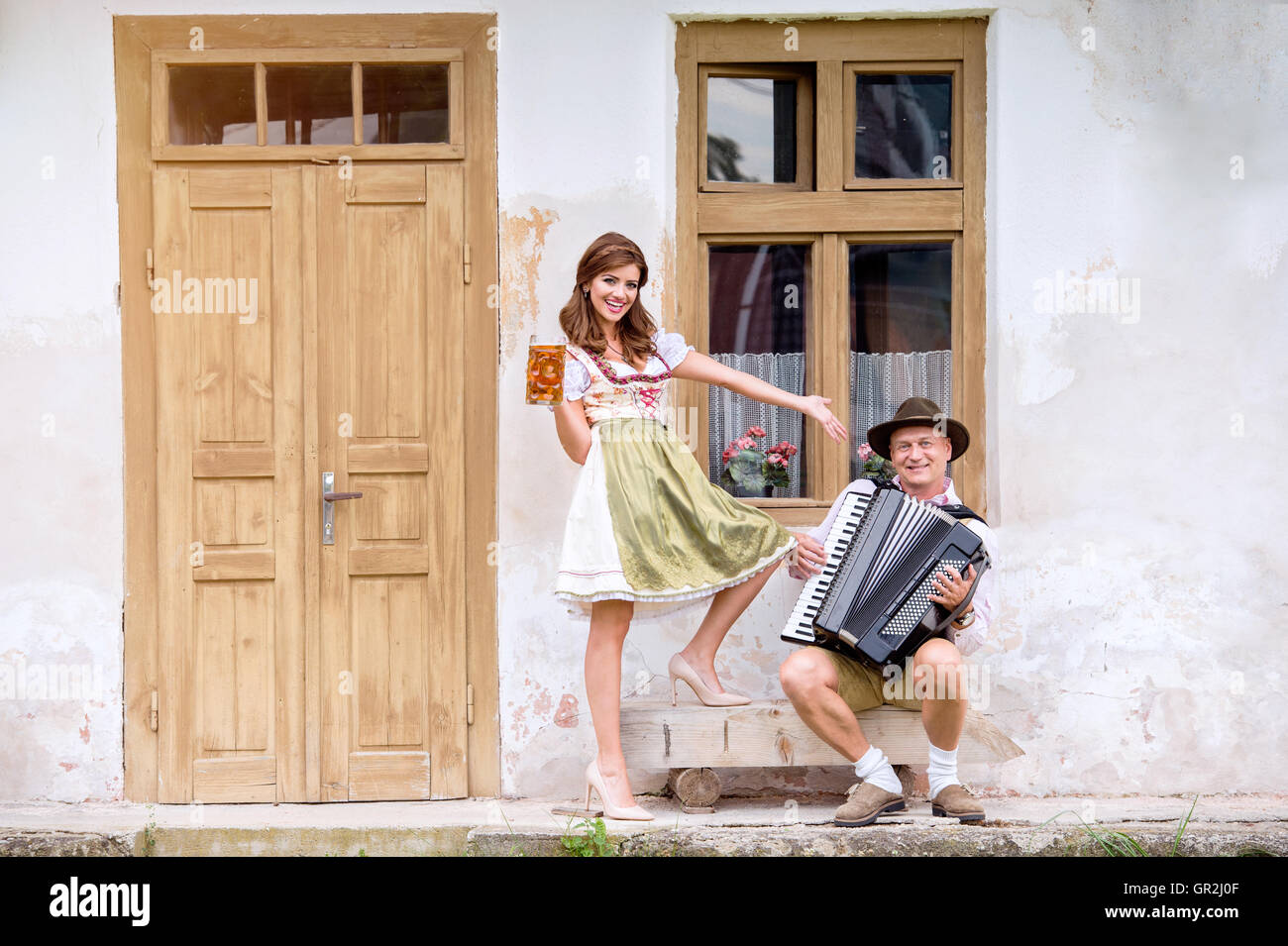 Paar in bayerischer Tracht mit Bier und Akkordeon Stockfoto