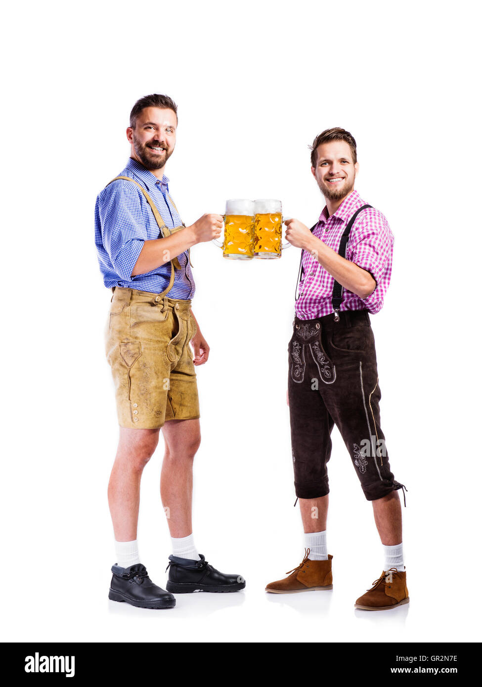 Männer in bayerischer Tracht Becher Bier halten Stockfoto