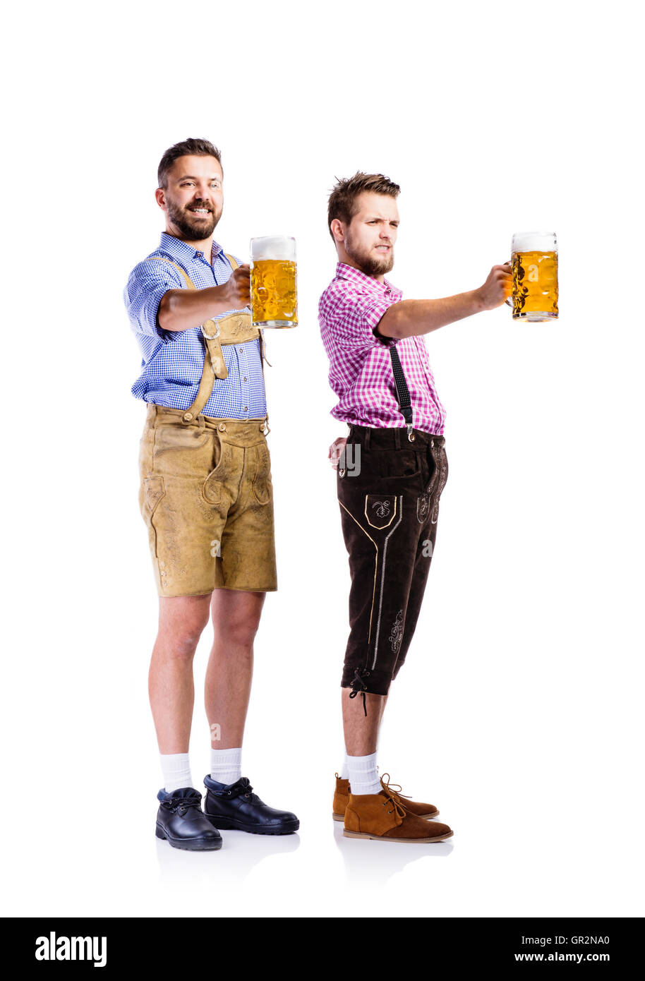 Männer in bayerischer Tracht Becher Bier halten Stockfoto