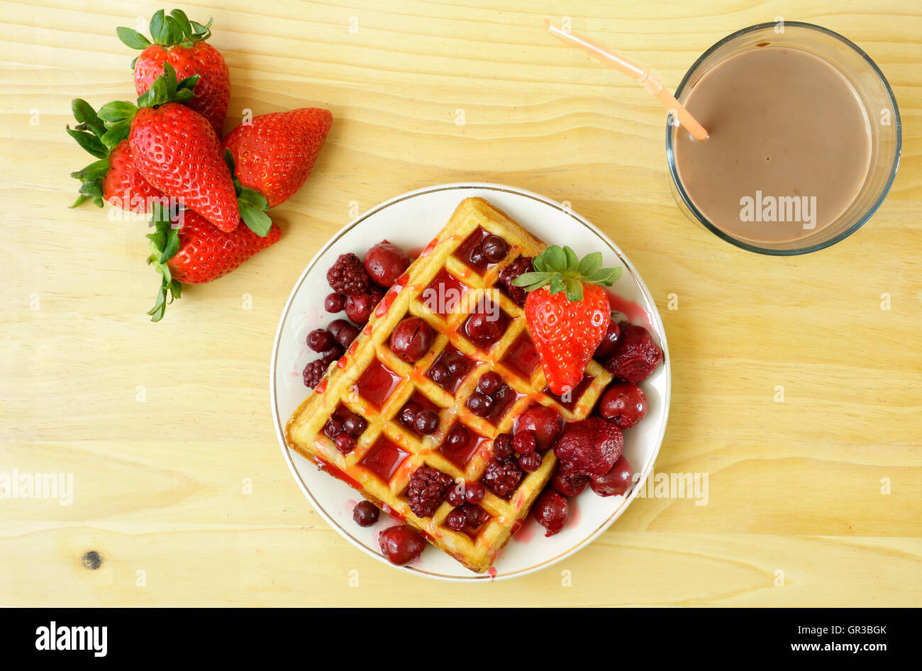 Nahaufnahme von leckeren Waffeln mit roten Beeren und Schokolade Smoothy auf hölzernen Hintergrund Stockfoto