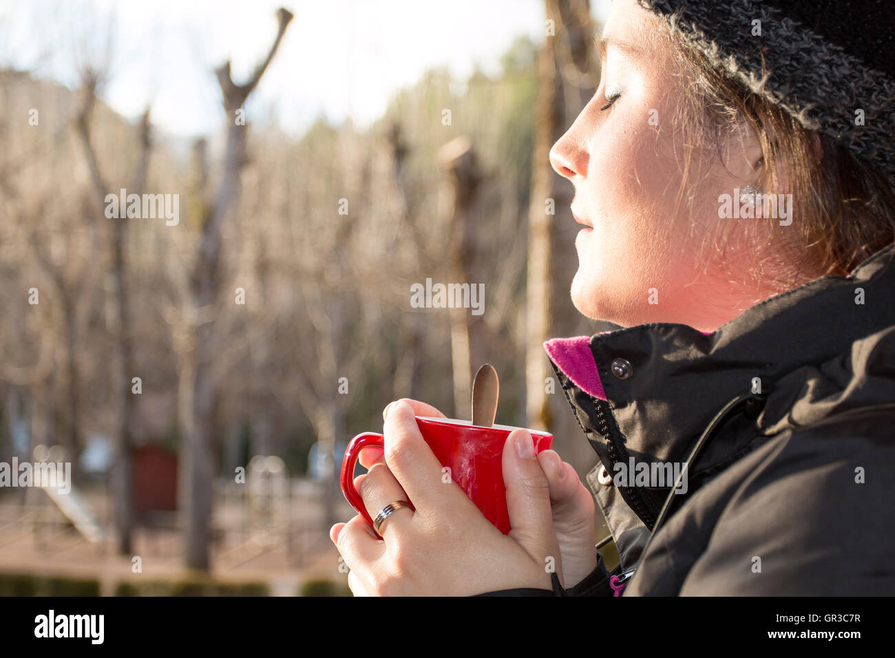Schöne Frau hält eine rote Tasse mit Kaffee im sunrise Stockfoto