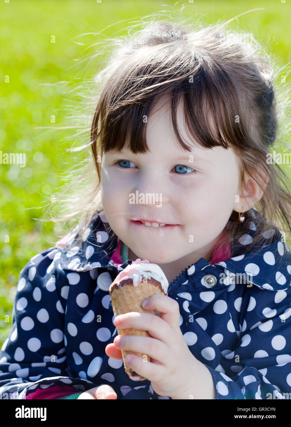 kleines Mädchen isst Eis auf der Straße Stockfoto