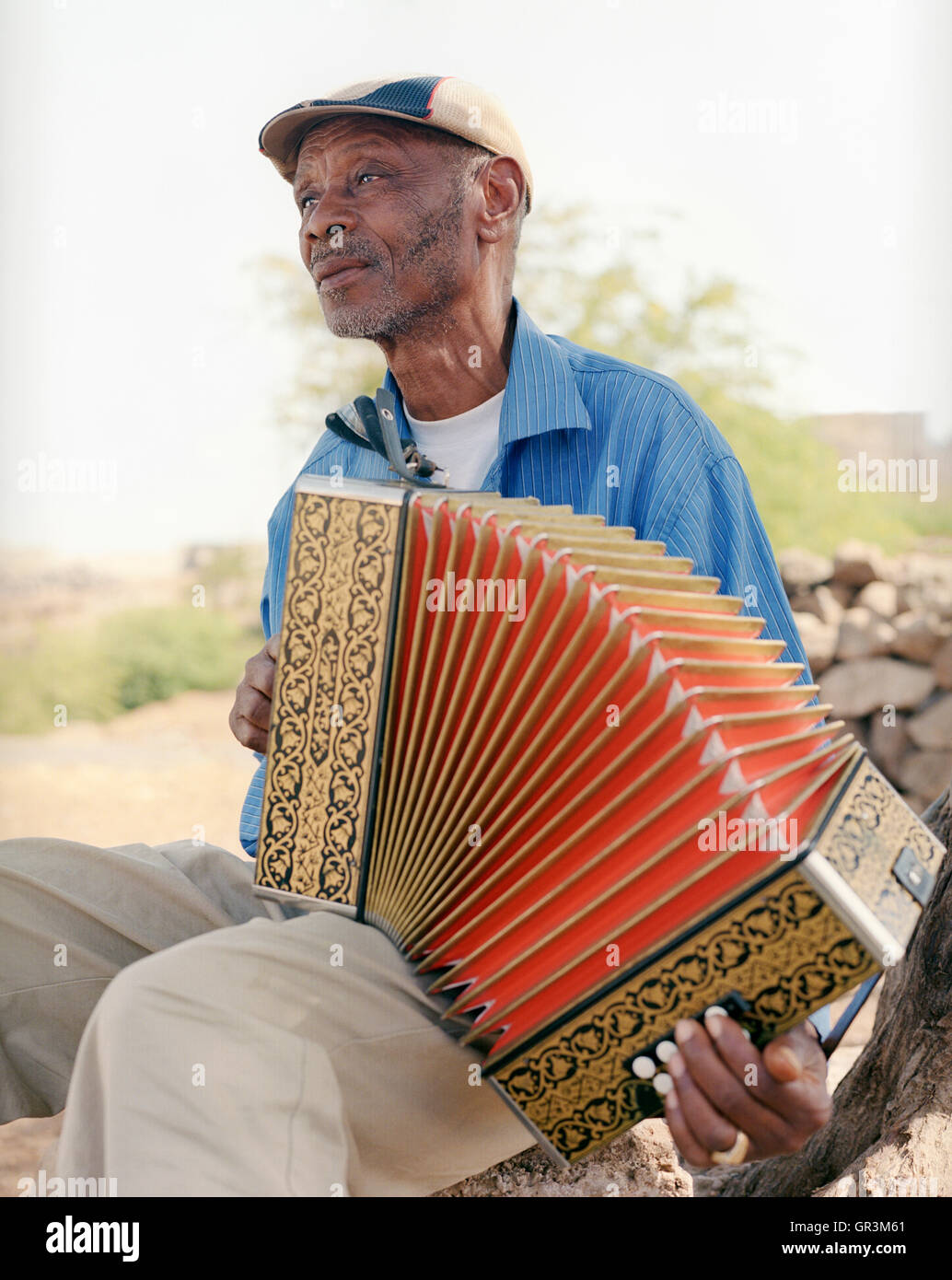 Grigorio Viaz den Spitznamen "Code de Dona' (Großmütter der Favorit) sitzt vor seinem Haus in Sao Francisco sein Akkordeon zu spielen. Stockfoto