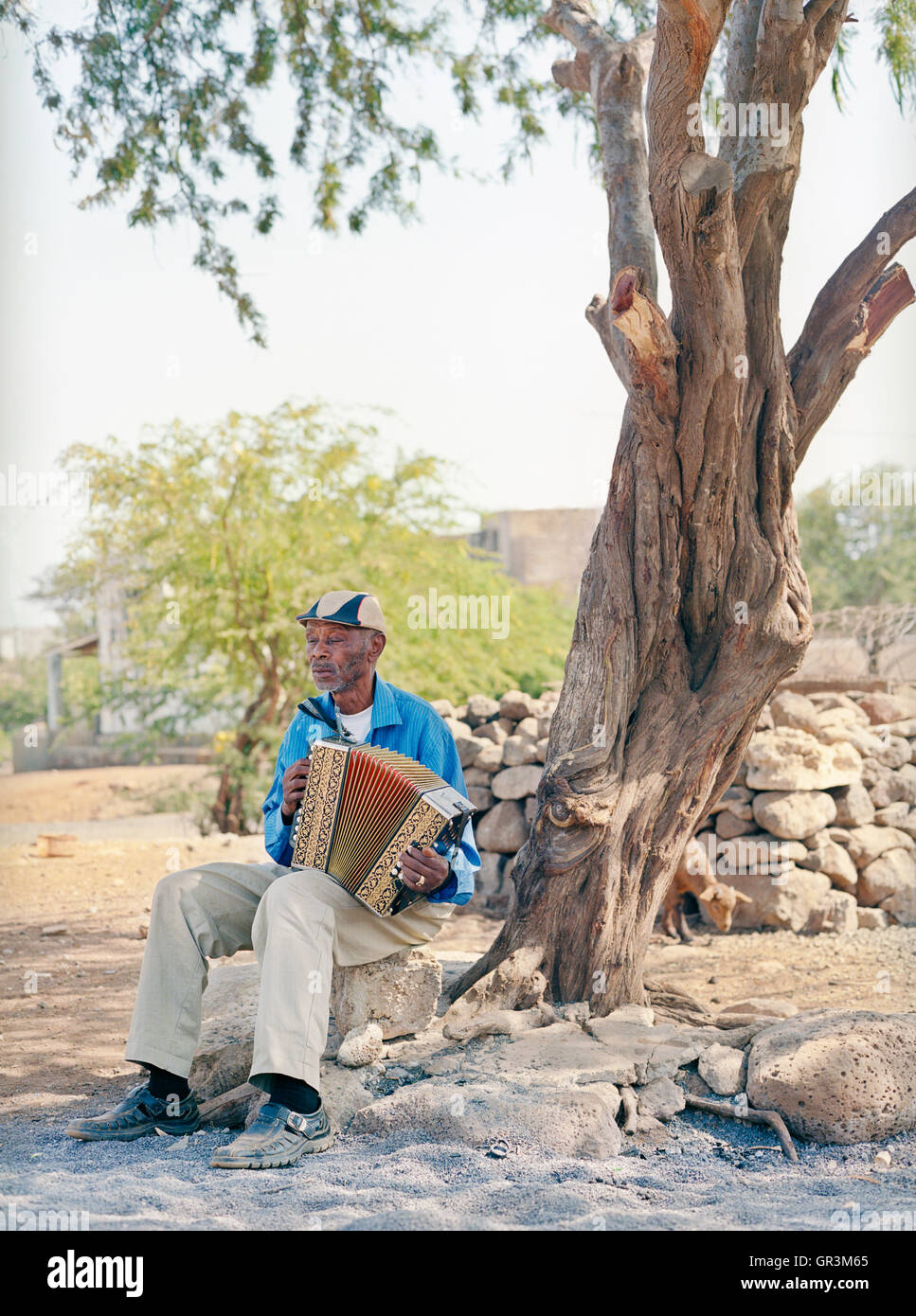 Grigorio Viaz den Spitznamen "Code de Dona' (Großmütter der Favorit) sitzt vor seinem Haus in Sao Francisco sein Akkordeon zu spielen. Stockfoto