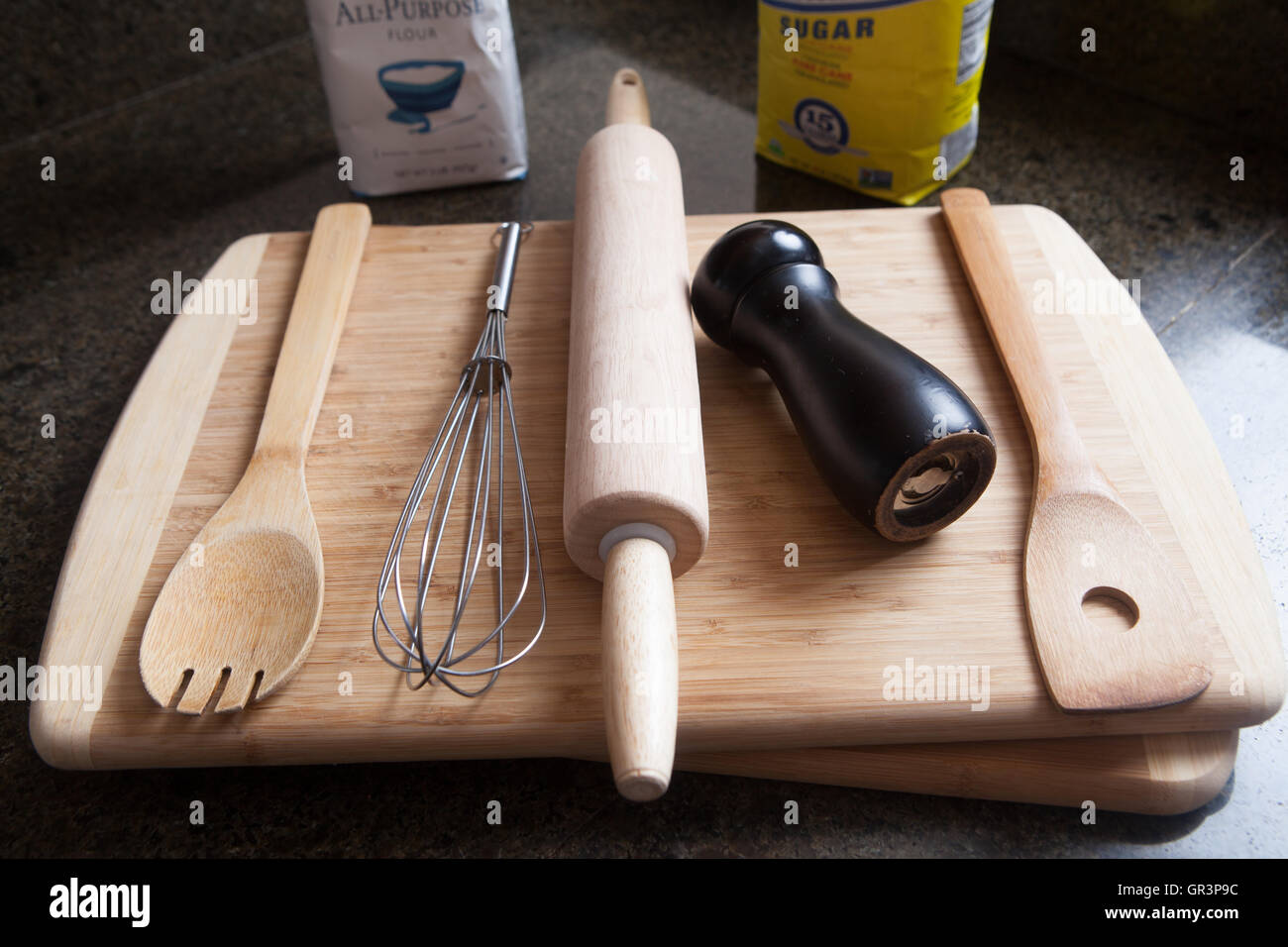 Schneiden von Holz Pfeffermühle, Zucker, Teig, Board Kochlöffel Schneebesen Nudelholz Holzspatel, schwarze Marmor Top, Licht-Box, Stockfoto