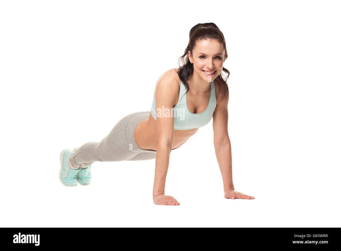 sportliche Frau Liegestütze auf einem weißen Hintergrund zu tun. Fitness-Modell mit einem schönen, sportlichen Körper Stockfoto