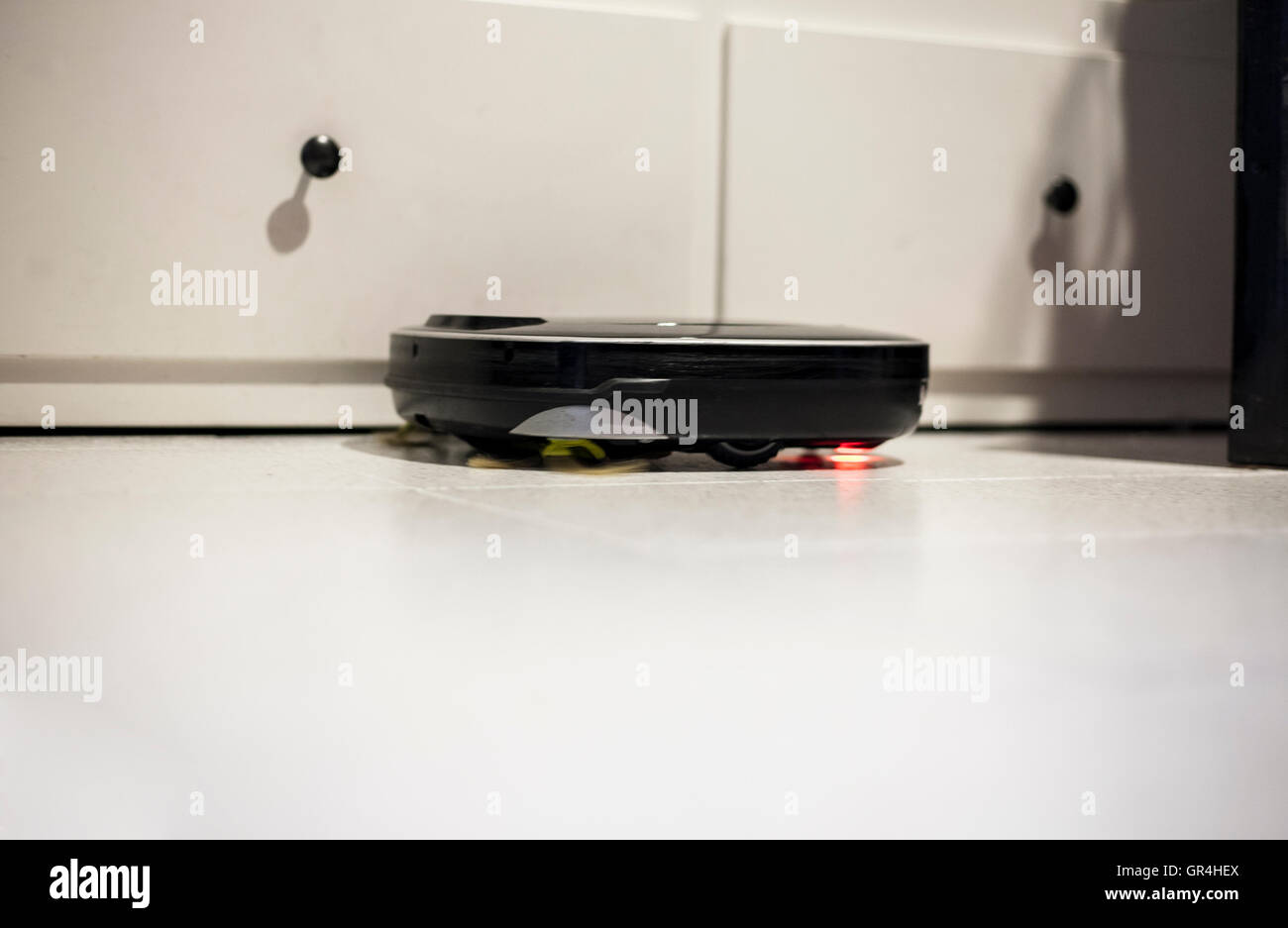 Roboter-Staubsauger auf glasierten Fliesen bei der Arbeit. Zeitlupe erschossen Stockfoto