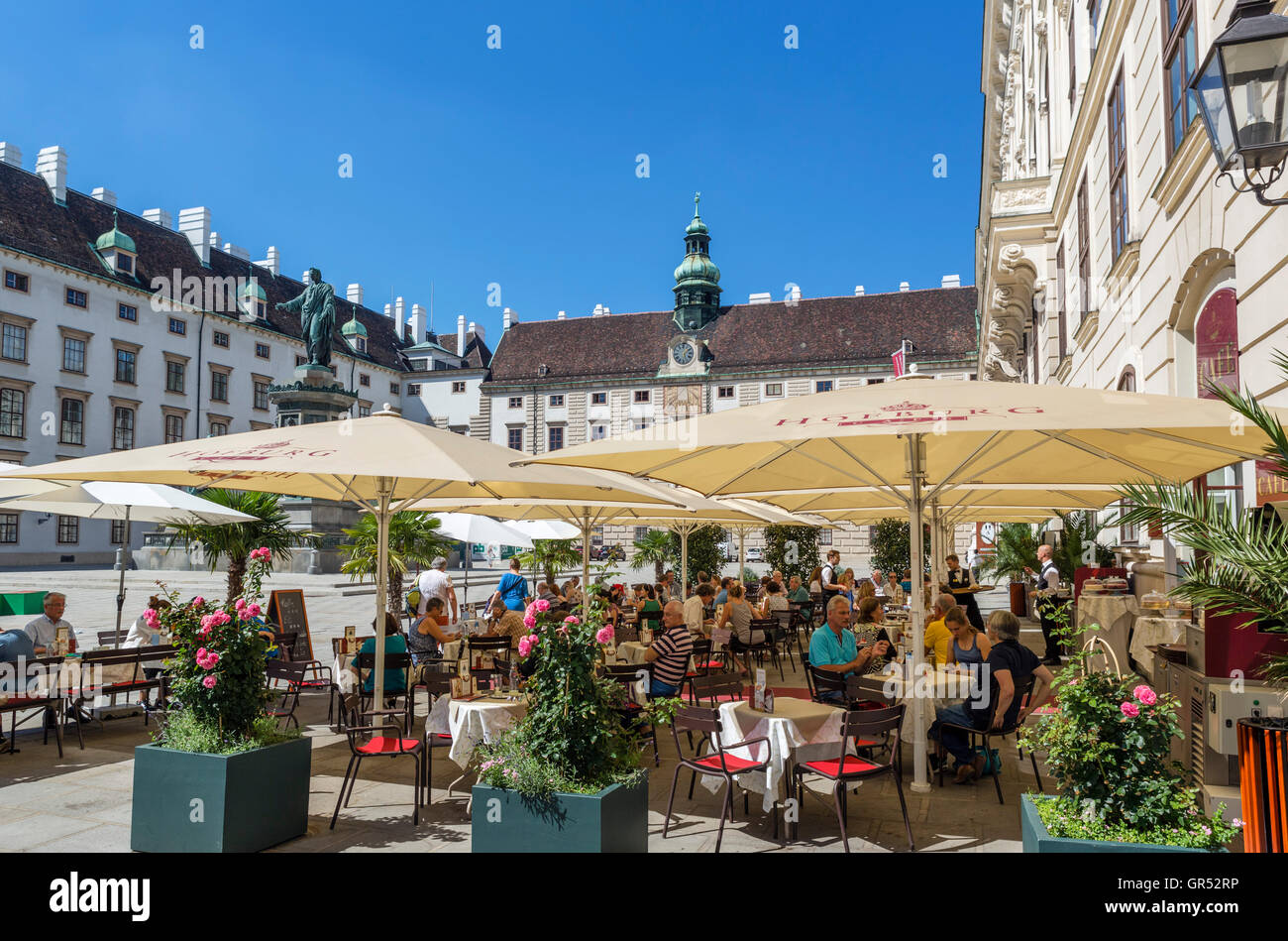 Wien, Cafe. Restaurant vor der Reichskanzleitrakt (kaiserliche Staatskanzlei Flügel), Hofburg Palast, Wien, Österreich. Stockfoto