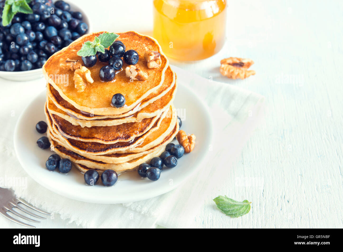 Hausgemachte Pfannkuchen mit Heidelbeeren, Honig und Walnüssen zum Frühstück Stockfoto