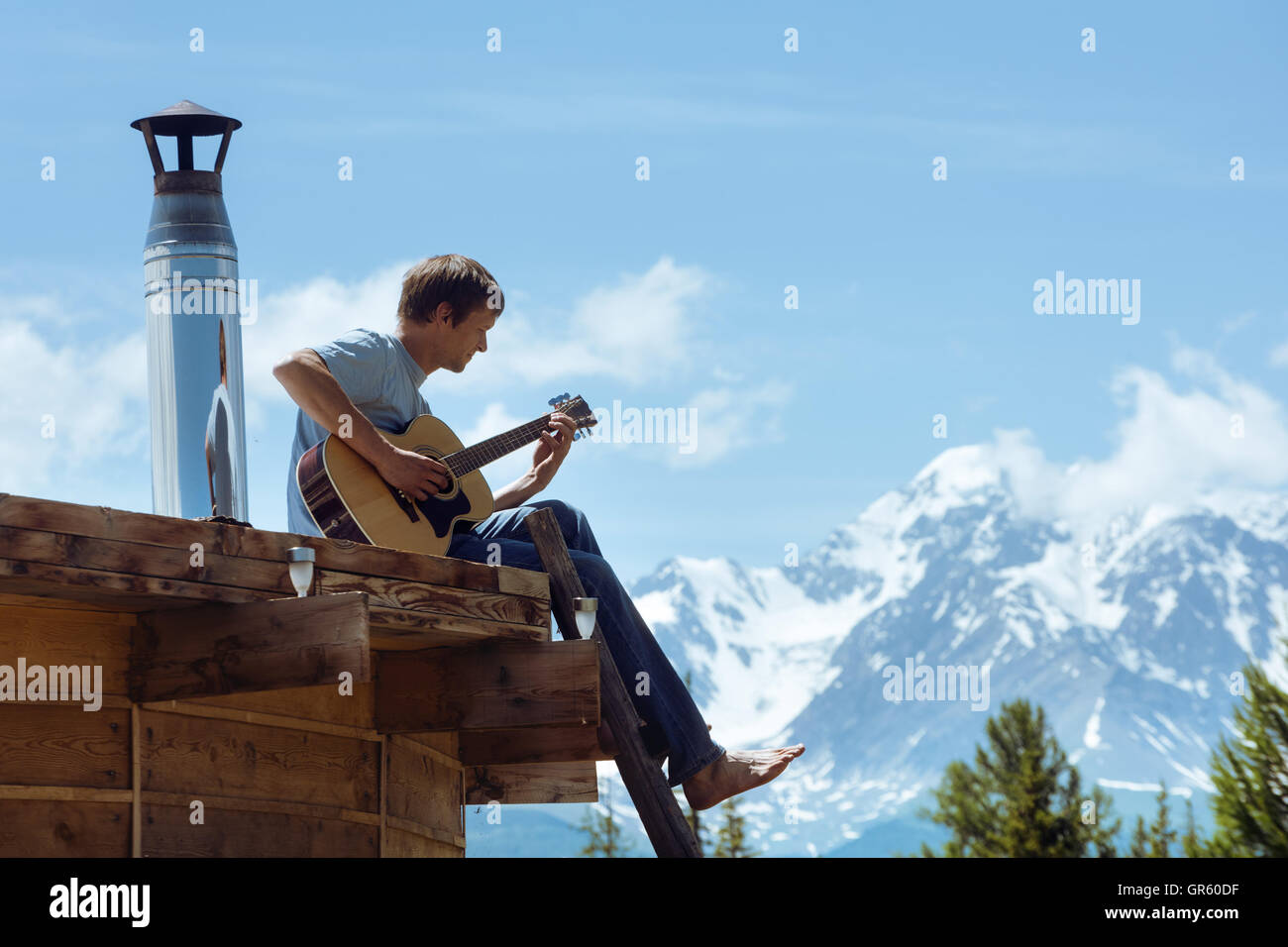 Man spielt auf der Gitarre auf dem Dach Stockfoto