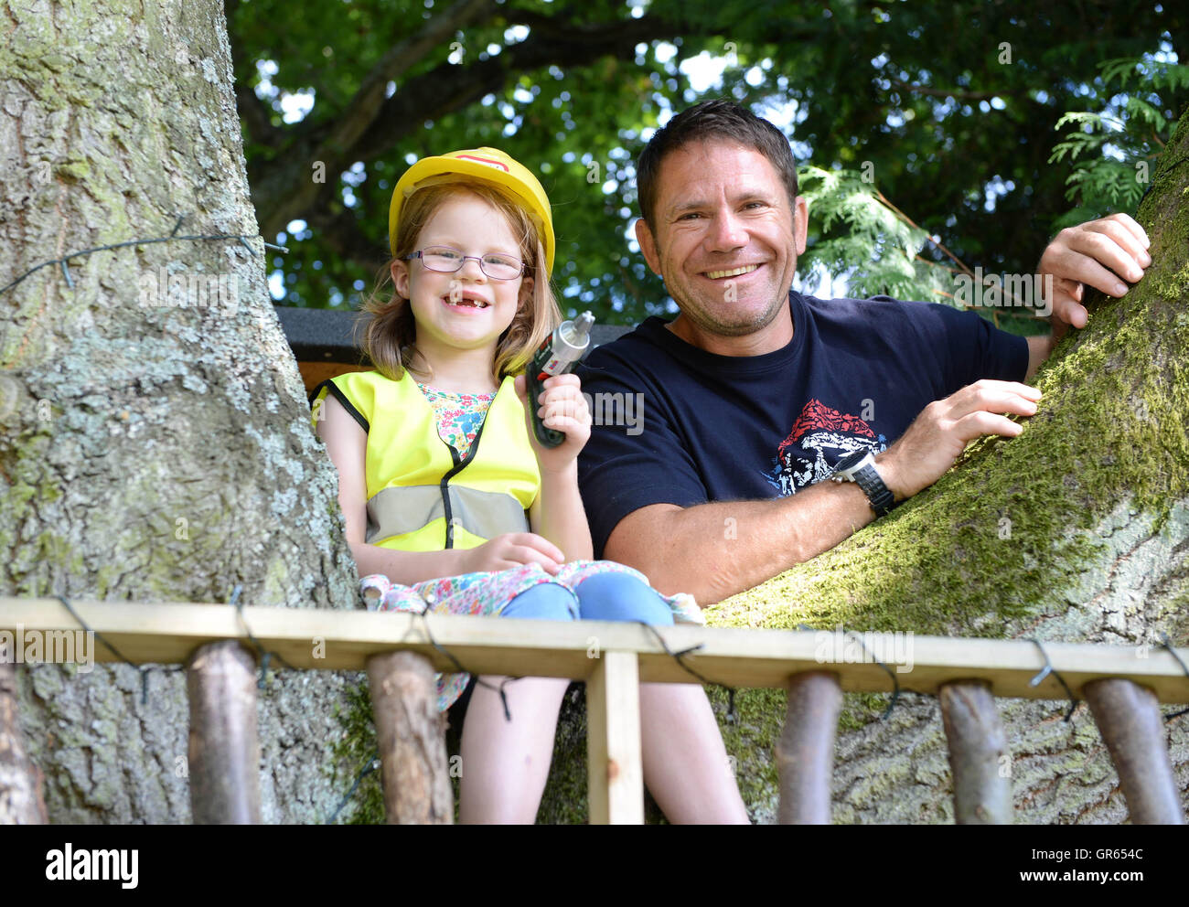 NUR zur redaktionellen Nutzung Abenteurer Steve Backshall präsentiert "The fernen Baumhaus" in Norwich, wie Center Parcs, der Gewinner des Wettbewerbs die UK Top Baumhaus von sechs-jährigen Ruby Jennings Besitz (links) und ihre Eltern Matthew und Becki errichtete. Stockfoto
