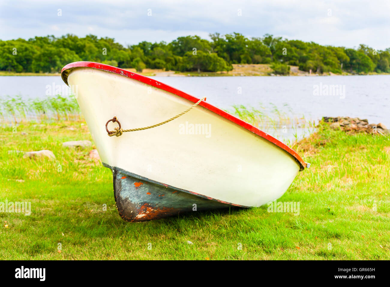 Rot und gelblich weißen Kunststoff Ruderboot auf dem Land liegen. Stockfoto