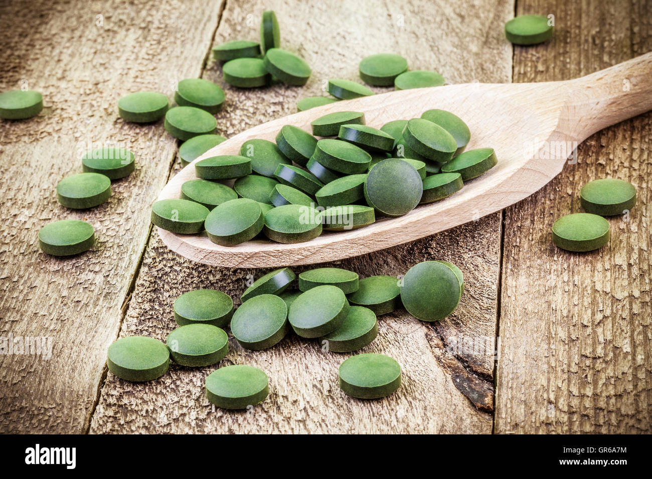 Spirulina, Chlorella Supplement Pillen in Holzlöffel Stockfoto