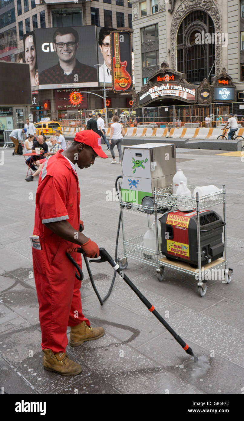 GUM-BUSTER. Ein Mann reinigt Kaugummi aus dem Boden auf dem Times Square in Midtown Manhattan, New York City Stockfoto