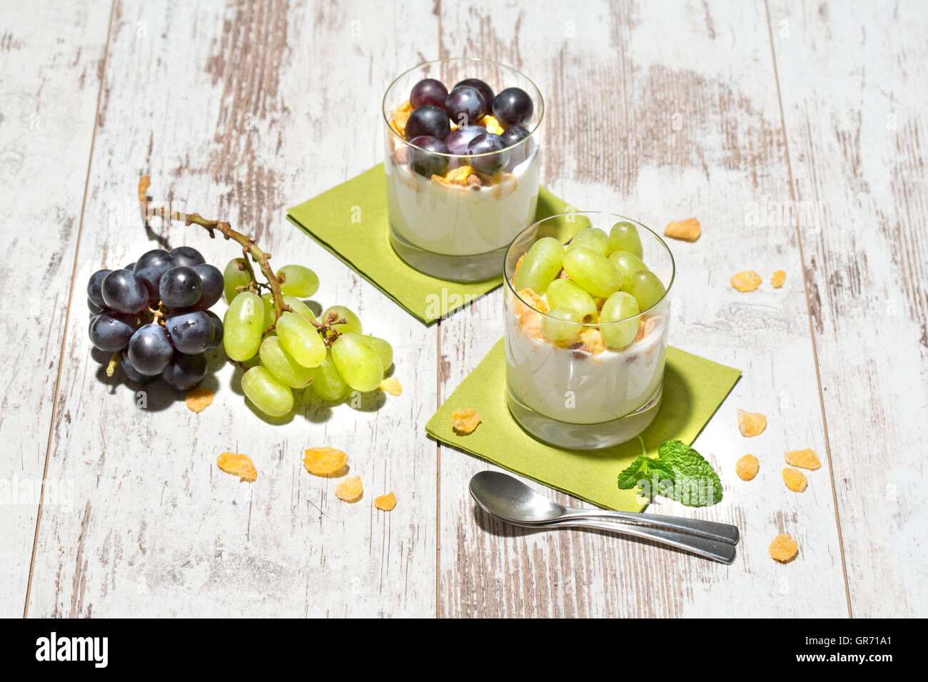 Fettarmer Joghurt mit Cornflakes und Trauben frischer Minze Stockfoto