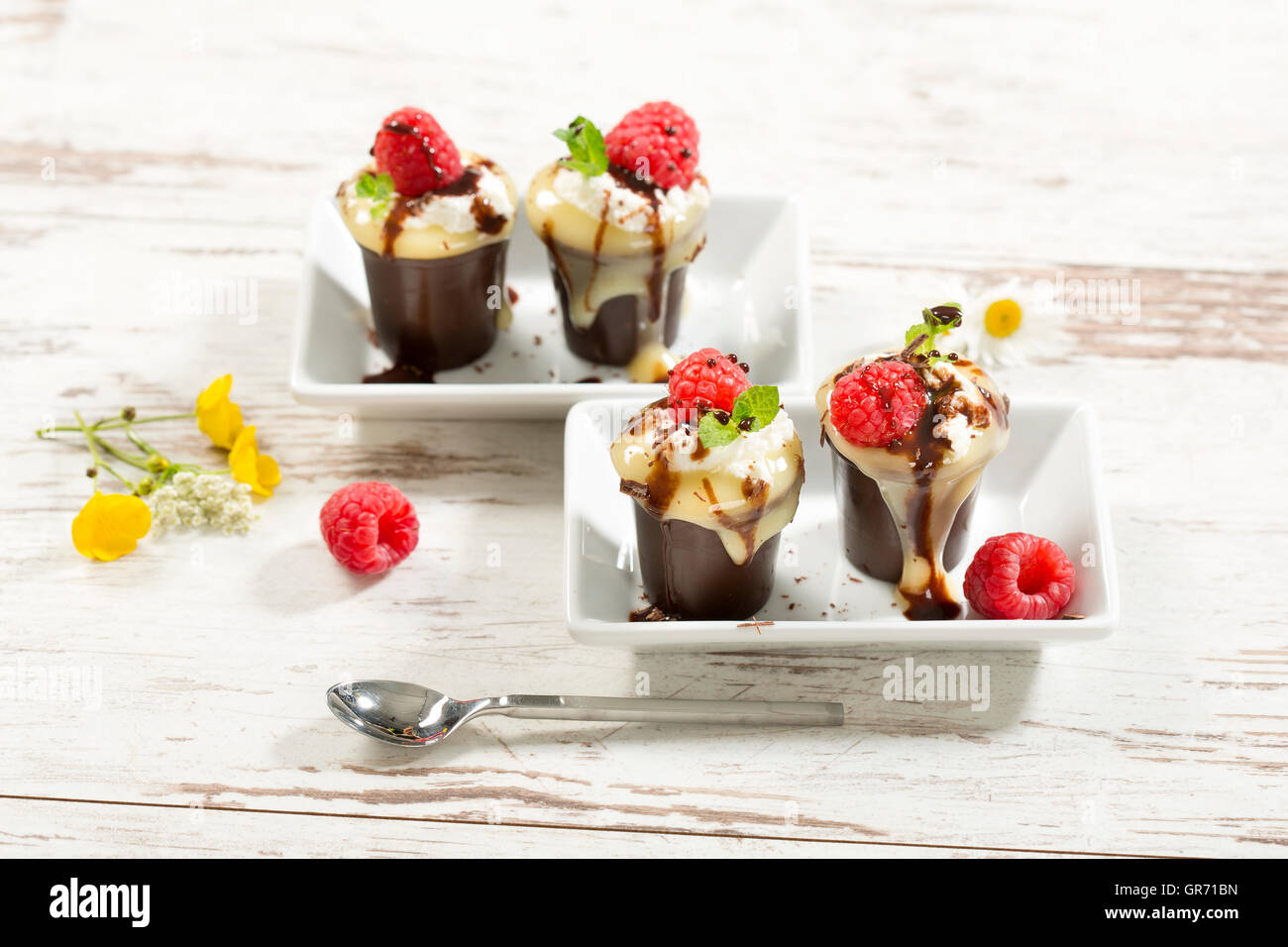 Schokolade Tasse mit Pudding Sahne und Himbeeren Stockfoto