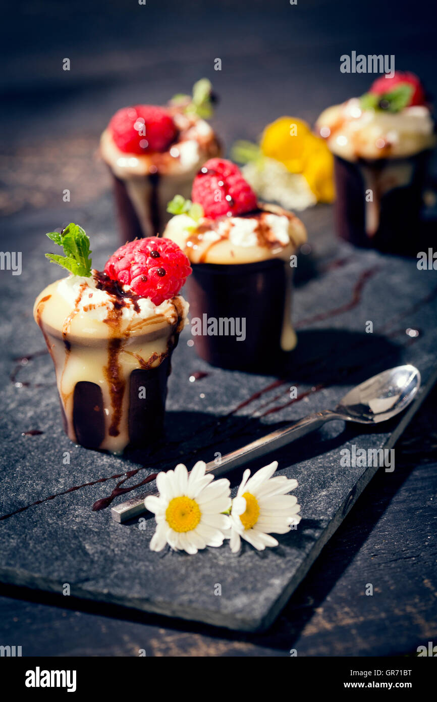 Schokolade Tasse mit Pudding Sahne und Himbeeren Stockfoto