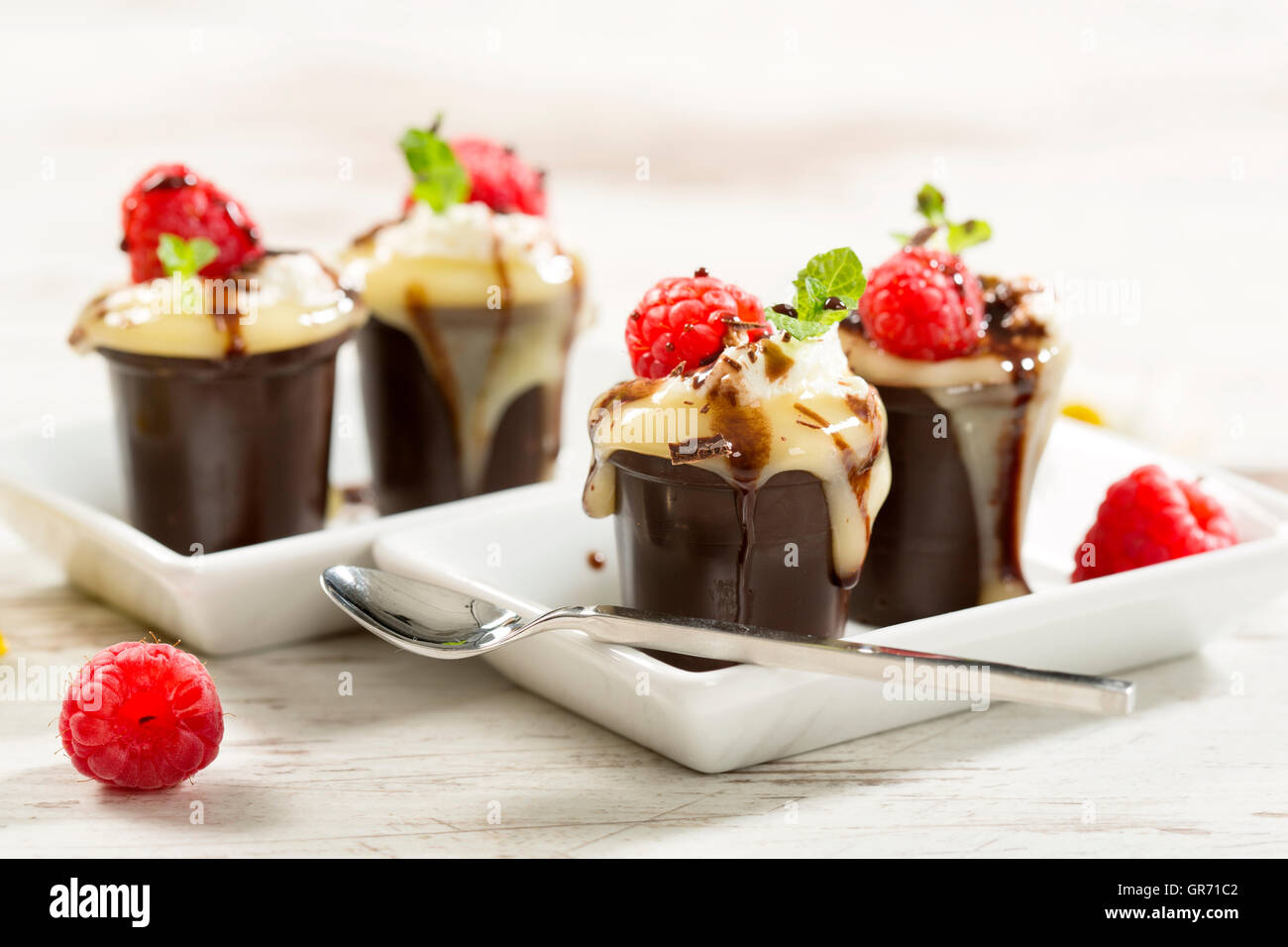 Schokolade Tasse mit Pudding Sahne und Himbeeren Stockfoto