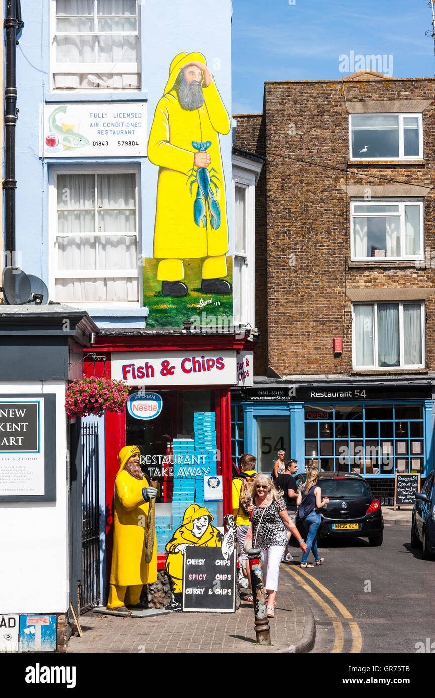 Traditionelle englische Fisch und Chip Shop in Main Street, Broadstairs, England. Tagsüber. Modell für die Fischer draußen auf Bürgersteig und Cut-out an der Wand. Stockfoto