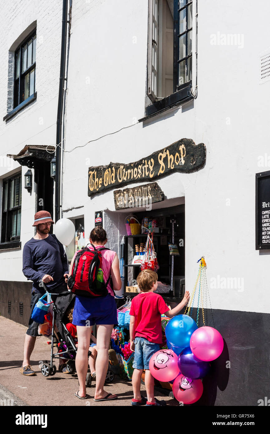 England, Broadstairs. The Old Curiosity Shop, Familie mit Kinderwagen und älteren Kind außerhalb Fenster kaufen Eis. Luftballons hängen an der Wand. Stockfoto