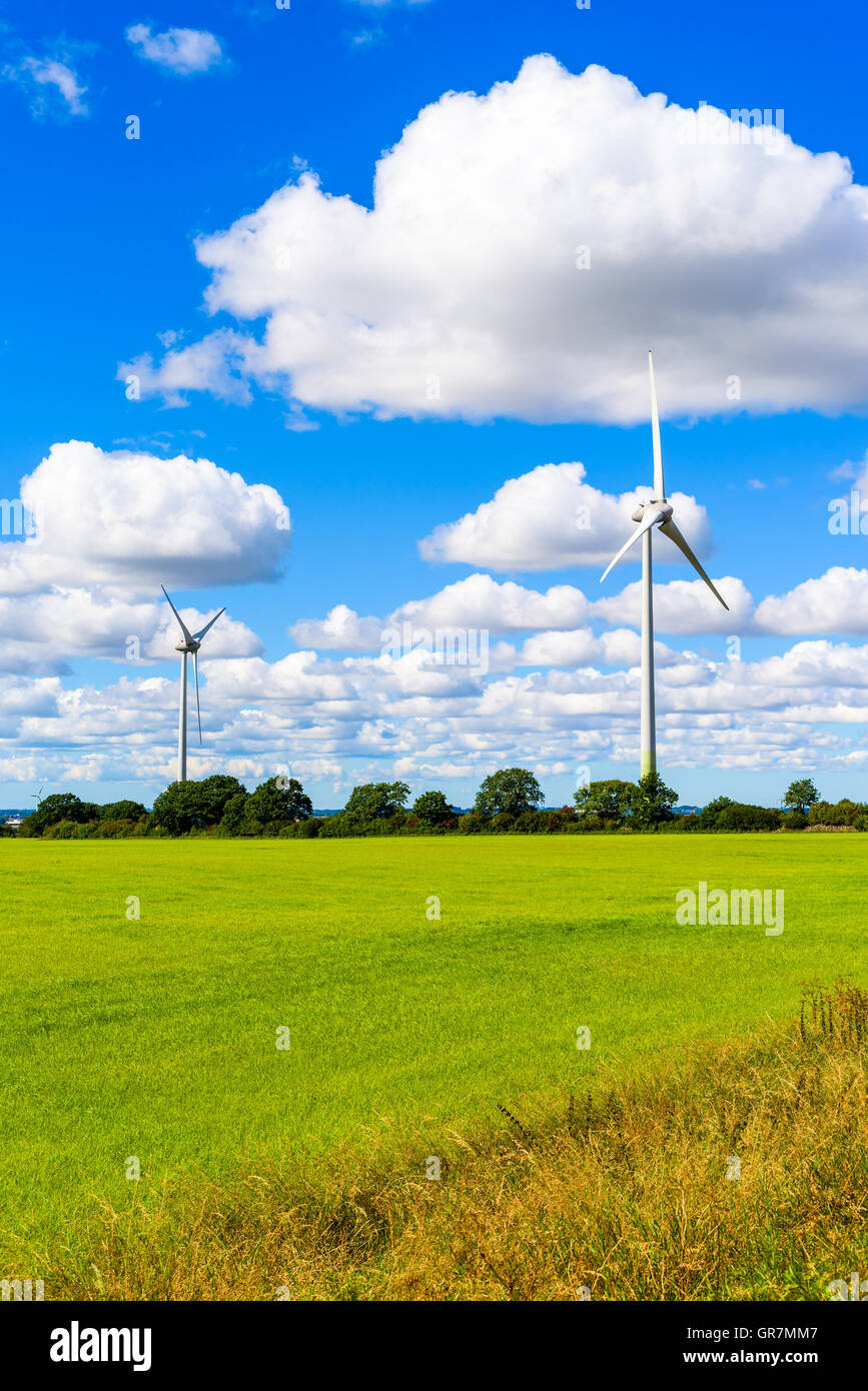 Nachhaltige Energie aus Windkraftanlagen in flachen Ackerland mit feinen Wolken Overhead. Skane in Südschweden. Stockfoto