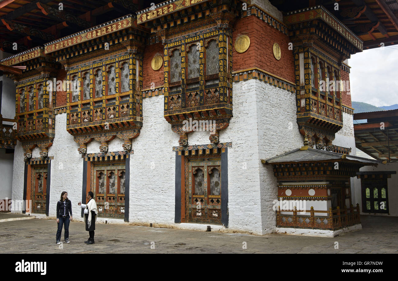 Stadtführer mit Besucher im Hof des Klosters und Festung Punakha Dzong, Punakah, Bhutan Stockfoto
